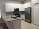 Modern kitchen featuring white cabinets, stainless steel appliances, and granite countertops at 7508 Lake Marsha Dr, Orlando, FL 32819