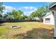 Spacious backyard featuring a fire pit, surrounded by a wooden fence and mature trees, ideal for relaxation at 8004 Village Green Rd, Orlando, FL 32818