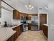 Charming kitchen featuring wood cabinets, stainless steel appliances, and ample counter space at 8004 Village Green Rd, Orlando, FL 32818