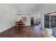 Open-concept living and dining area with hardwood floors, chandelier, and sliding glass doors to the patio at 8004 Village Green Rd, Orlando, FL 32818