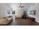 Comfortable living room with hardwood floors, ceiling fan, and cozy seating arrangement for relaxation at 8004 Village Green Rd, Orlando, FL 32818