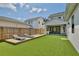 Landscaped backyard with artificial turf, deck with chaise lounges, and outdoor kitchen at 833 Dartmouth St, Orlando, FL 32804
