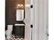 Modern powder room with dark accent wall, sleek vanity, and eye-catching black and white hexagon tile floor at 833 Dartmouth St, Orlando, FL 32804