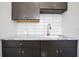Wet bar area featuring sleek granite countertops, modern cabinetry, subway tile backsplash and stainless steel faucet at 833 Dartmouth St, Orlando, FL 32804