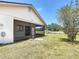 Exterior view of the screened-in patio in the backyard, with a tree at 857 E Flag Ln, Kissimmee, FL 34759