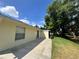 View of the back of the house and patio with a big tree for shade at 8829 Courtyard Ln, Groveland, FL 34736