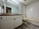 Bathroom featuring a tub with shower and large white sink and cabinets at 8829 Courtyard Ln, Groveland, FL 34736