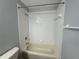 Bathroom with a large tub and shower in a white tiled space at 8829 Courtyard Ln, Groveland, FL 34736