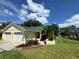 Beautiful home featuring an attached two-car garage, lush landscaping, and a welcoming walkway at 8829 Courtyard Ln, Groveland, FL 34736