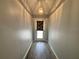 View of a well-lit hallway with wood-look flooring and an elegant pendant light fixture at 8829 Courtyard Ln, Groveland, FL 34736