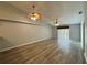 Spacious living room with hardwood floors, ceiling fans, and natural light from sliding glass doors at 8829 Courtyard Ln, Groveland, FL 34736