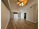 Open-concept living room with hardwood floors, ceiling fans, and access to an outdoor space at 8829 Courtyard Ln, Groveland, FL 34736