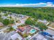 Aerial view of neighborhood home with solar panels, pool, backyard, and wooded backdrop at 898 Hendry Dr, Orlando, FL 32822