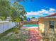 Backyard featuring a pool, patio, mature trees, privacy fence, and lush landscaping at 898 Hendry Dr, Orlando, FL 32822