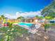 Spacious backyard with a pool, sunroom, playground, pergola, and lush landscaping at 898 Hendry Dr, Orlando, FL 32822