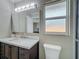 Bathroom featuring vanity, mirror, lights, frosted window, and toilet at 898 Hendry Dr, Orlando, FL 32822