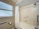 Clean bathroom featuring grab bars, a shower/tub, and a frosted window at 898 Hendry Dr, Orlando, FL 32822