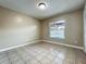 Bright bedroom features tile floors and a window overlooking the pool area at 898 Hendry Dr, Orlando, FL 32822