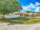 Charming home with a manicured lawn, stone accents and a red exterior, surrounded by lush greenery at 898 Hendry Dr, Orlando, FL 32822