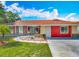 Charming home featuring stone accents, a red exterior, and a well-maintained landscaped front yard at 898 Hendry Dr, Orlando, FL 32822