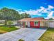 Beautiful home featuring stone accents, a red exterior, and a well-maintained landscaped front yard at 898 Hendry Dr, Orlando, FL 32822