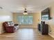 Bright living room featuring wood floors, ceiling fan and modern entertainment center at 898 Hendry Dr, Orlando, FL 32822