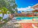 Backyard pool and patio featuring lounge chairs, BBQ, play set, and decorative landscaping at 898 Hendry Dr, Orlando, FL 32822