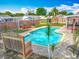 Backyard oasis featuring a pristine pool, lush greenery, a playset, and privacy fence at 898 Hendry Dr, Orlando, FL 32822