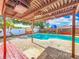 Backyard featuring a pool with lounge chairs, a covered pergola, and lush greenery at 898 Hendry Dr, Orlando, FL 32822