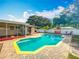 Backyard pool area with a sunroom, covered pergola, lush landscaping, and privacy fence at 898 Hendry Dr, Orlando, FL 32822