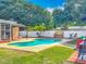 Backyard pool area with a covered pergola, privacy fence, and lush landscaping at 898 Hendry Dr, Orlando, FL 32822