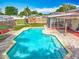 Aerial view of a backyard with a beautiful in-ground pool, a screen porch, and a play structure at 898 Hendry Dr, Orlando, FL 32822
