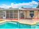 The backyard pool is surrounded by the screened in back porch and outdoor seating under a canopy at 898 Hendry Dr, Orlando, FL 32822