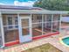The enclosed back porch offers a basketball hoop and seating with access to the backyard pool at 898 Hendry Dr, Orlando, FL 32822