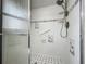 White tiled shower with shelving, safety bar, and decorative trim at 898 Hendry Dr, Orlando, FL 32822