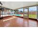 Enclosed sunroom featuring tile flooring and views of the backyard pool, basketball hoop, and privacy fence at 898 Hendry Dr, Orlando, FL 32822