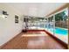 Enclosed sunroom featuring tile flooring and views of the backyard pool and basketball hoop at 898 Hendry Dr, Orlando, FL 32822