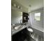 Bathroom features a dark vanity, toilet, shower/tub combo, and decorative shelves at 9028 Se 41St Court Rd, Ocala, FL 34480