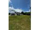 Spacious front yard with green grass featuring a single-story home with a paved driveway and attached garage at 9028 Se 41St Court Rd, Ocala, FL 34480