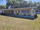 Charming single-story home with a covered porch, light yellow paint, and verdant landscaping at 936 Pinedale Ave, Orlando, FL 32808