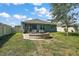This backyard has a brick patio with seating, a grassy area, and a white fence at 6768 Coral Berry Dr, Mount Dora, FL 32757