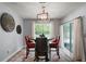 Cozy dining area with a modern chandelier, table with chairs, and natural light from a sliding glass door at 6768 Coral Berry Dr, Mount Dora, FL 32757