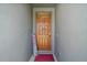 Inviting entryway showcasing a wooden front door, decorative accents and a welcoming sign at 6768 Coral Berry Dr, Mount Dora, FL 32757
