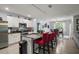 Modern kitchen with white cabinets, granite countertops, stainless steel appliances, and a breakfast bar at 6768 Coral Berry Dr, Mount Dora, FL 32757