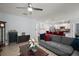 Open-concept living room with a gray sofa, a TV, and a view into the modern kitchen at 6768 Coral Berry Dr, Mount Dora, FL 32757