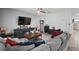 Comfortable living room featuring a large gray sofa, a TV and neutral wall color at 6768 Coral Berry Dr, Mount Dora, FL 32757