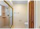 Modern shower featuring tiled walls, glass door, toilet, and shelving at 1003 Chesterfield Cir, Winter Springs, FL 32708