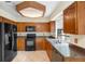 Traditional kitchen with wood cabinets, black appliances and plenty of natural light from the window at 1003 Chesterfield Cir, Winter Springs, FL 32708