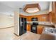 Traditional kitchen with wood cabinets, black appliances and tile flooring at 1003 Chesterfield Cir, Winter Springs, FL 32708