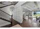 Bright foyer featuring hardwood floors, staircase, and an open view of the kitchen at 10196 Bucklow Hill Dr, Orlando, FL 32832